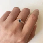 Swan Pırlanta London Blue Topaz Tektaş Yüzük, sarı altın bant üzerinde mavi taş merkezli, yanlarında beyaz pırlantalarla çevrili zarif tasarım detayları