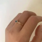 Swan Pırlanta London Blue Topaz tektaş yüzük, altın renkli zarif tasarım üzerinde mavi taş ve yan pırlantalarla dikkat çekici parıltı sunar.